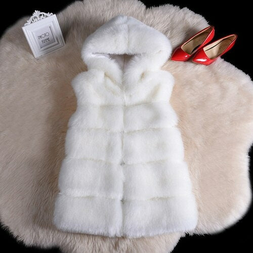 White faux fur sleeveless jacket displayed on fur rug with red high heels and product tag, highlighting luxurious and stylish design for winter fashion.