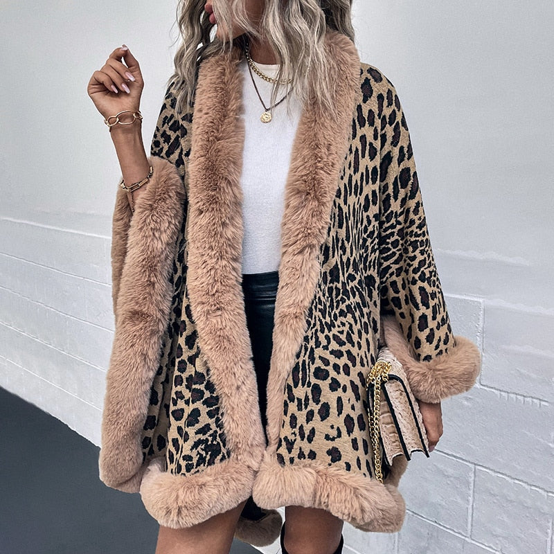 Woman wearing 2022 Winter Thick Warm Poncho Fur Collar Cape Coat with leopard print, styled with white top and leather skirt.