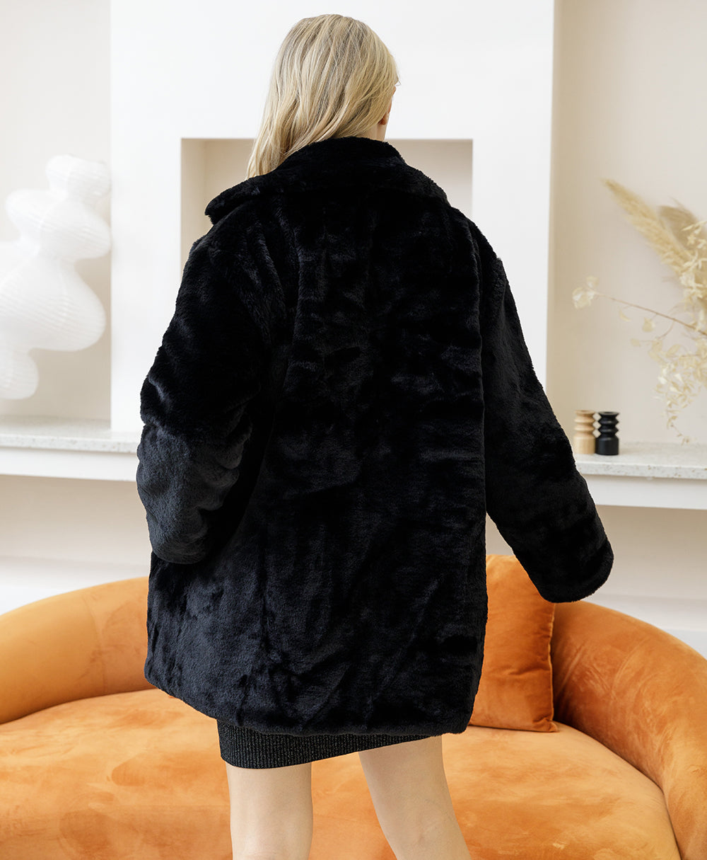 Woman wearing 2022 Autumn Winter faux fur coat, elegant and fluffy design, in a stylish modern living room setting.