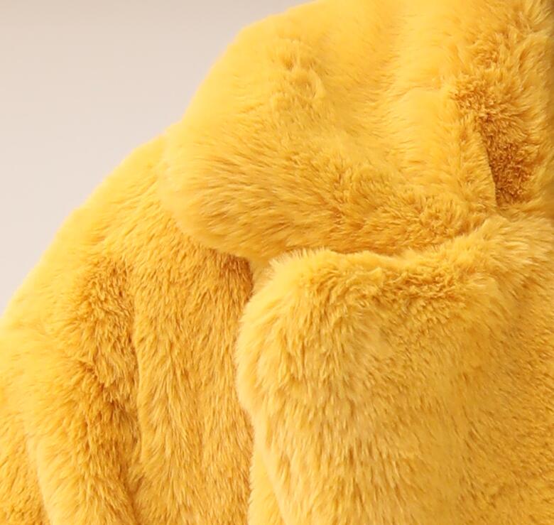 Close-up of a luxurious yellow faux fur coat with plush texture and elegant design details