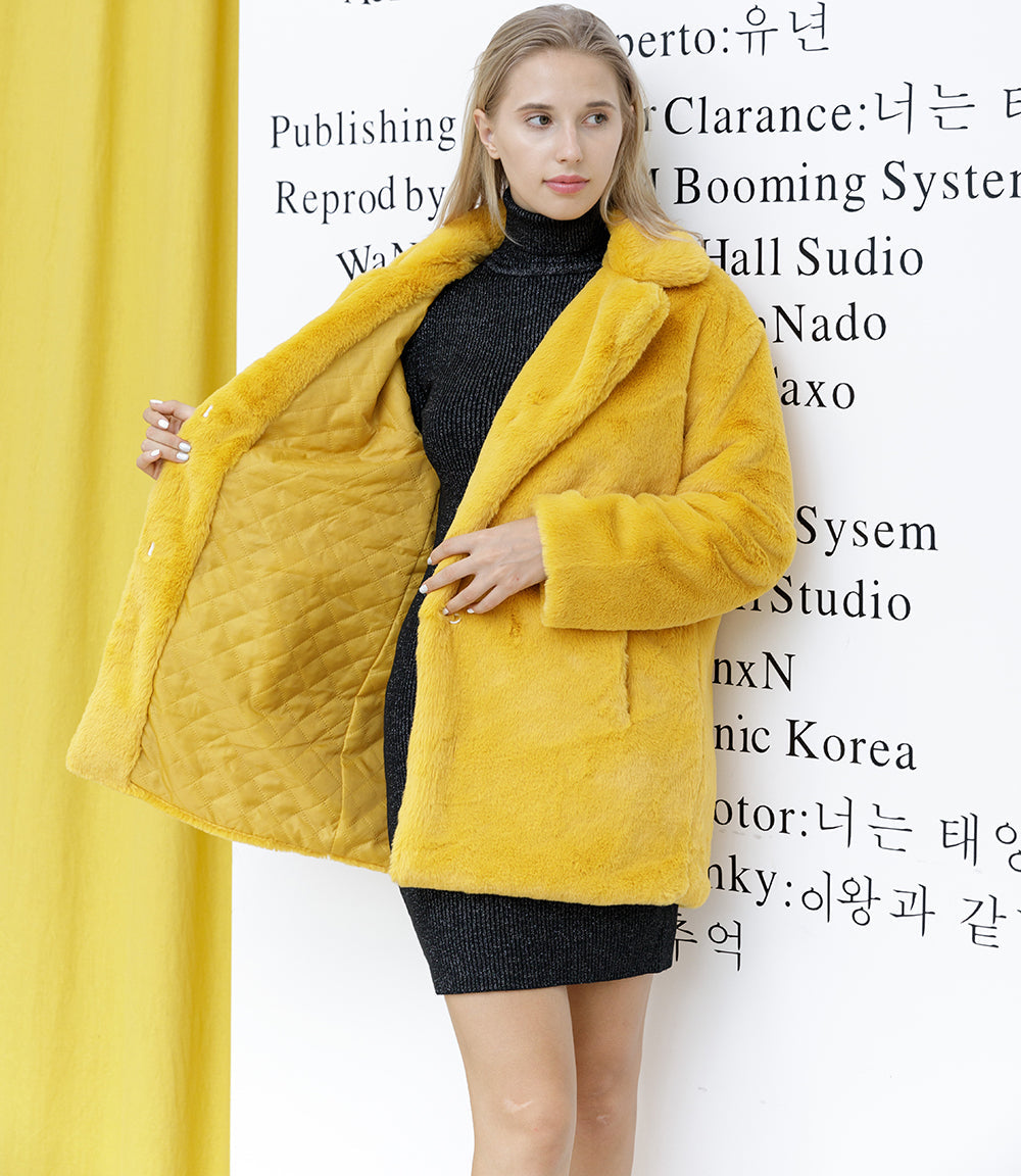 Woman in a stylish yellow faux fur coat over a black dress, posing against a backdrop with text, portraying autumn and winter fashion.