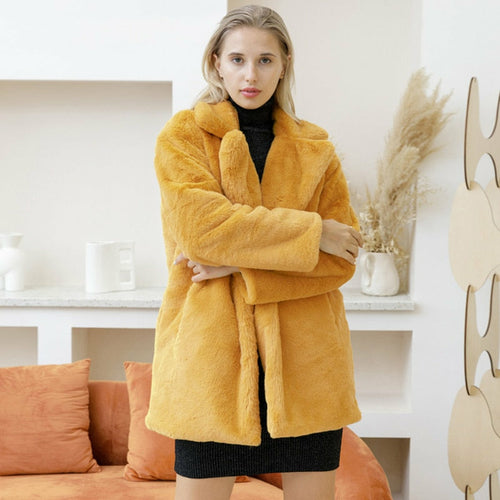 Woman wearing 2022 Autumn Winter elegant yellow faux fur coat in stylish home setting