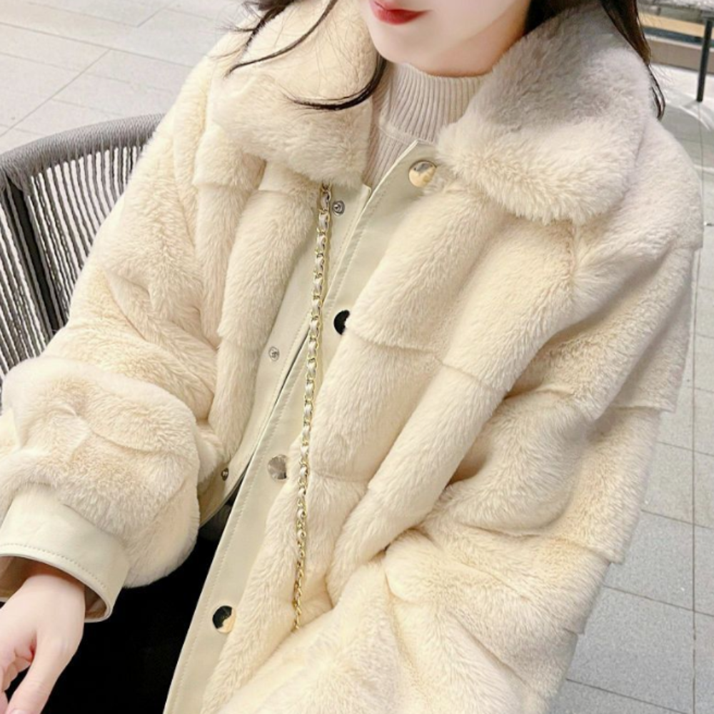 Woman in stylish faux fur jacket with vegan leather trimmed cuffs sitting on a city bench