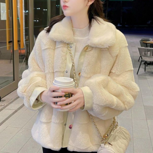 Woman wearing a stylish faux fur jacket with vegan leather trimmed cuffs, holding a coffee cup.