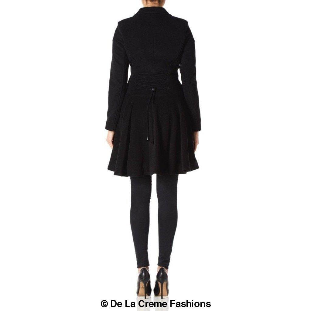 Rear view of a woman wearing a black Wool Blend Double Breasted Skater Coat (1102) by De La Creme Fashions, showcasing its flared design and waist tie detail.