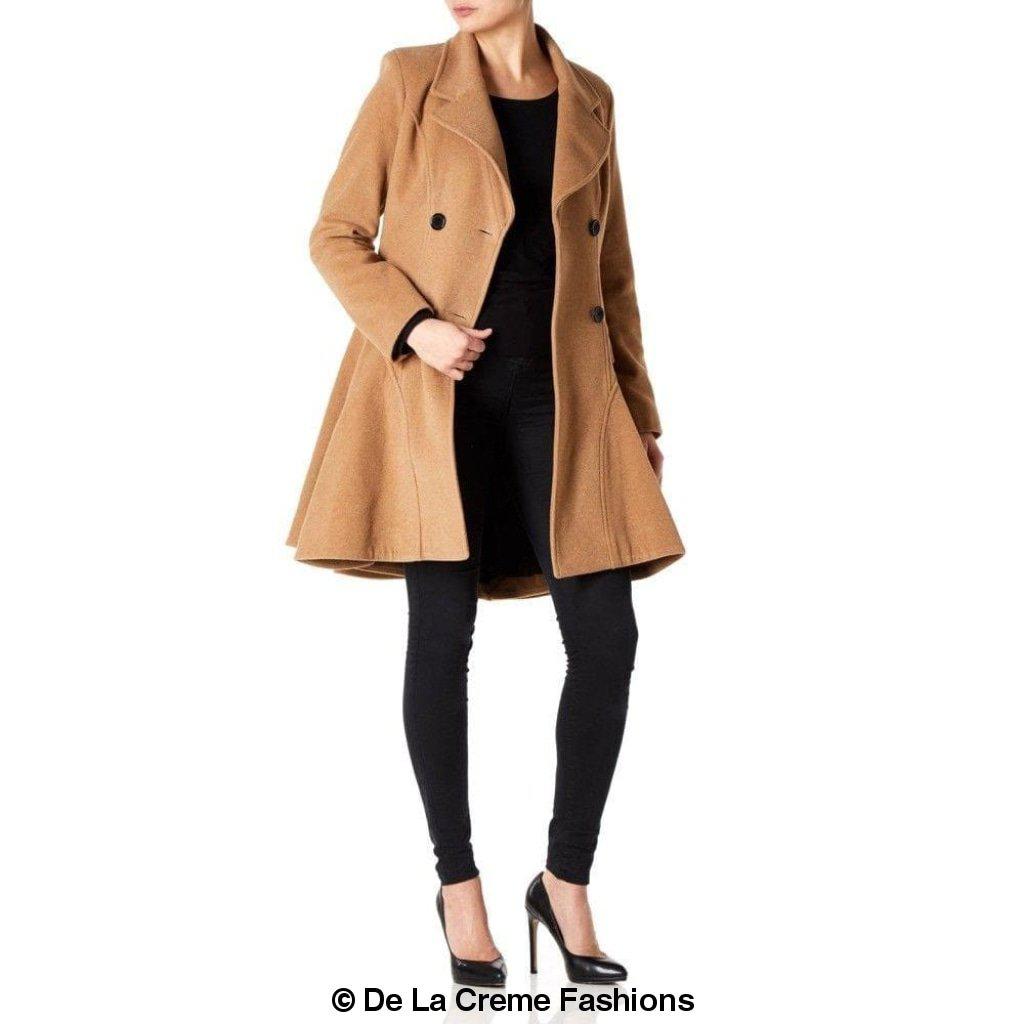 Woman modeling De La Creme Wool Blend Double Breasted Skater Coat, tan color, styled with black pants and heels.