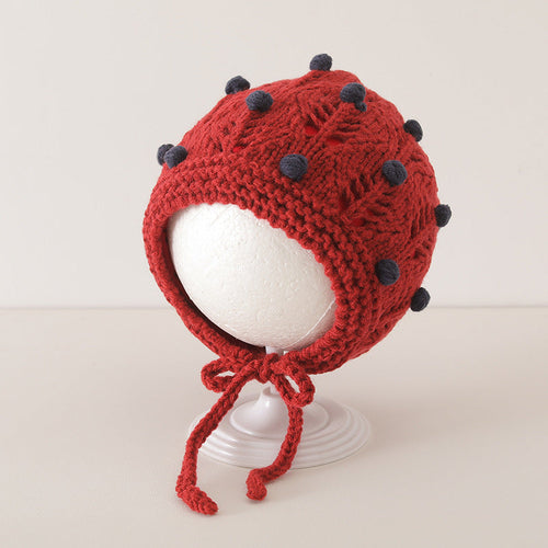 Red vintage design warm balaclava for baby with grey dot pattern on display stand