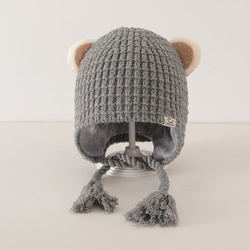 Grey knitted baby balaclava with cute ear details and tassel ties on a white background, ideal for winter warmth and style.