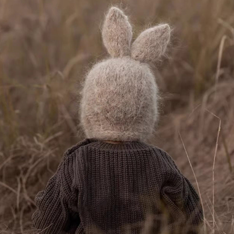 Baby in a field wearing a Winter and Autumn Rabbits Design Warm Fleece Balaclava with rabbit ears