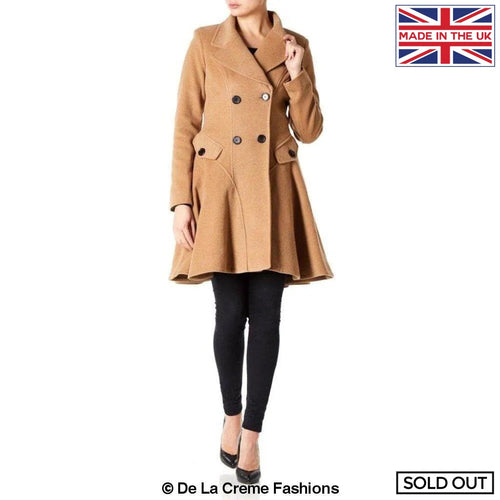 Woman modeling a De La Creme Wool Blend Double Breasted Skater Coat, tan color, styled with black pants and heels, marked as sold out.