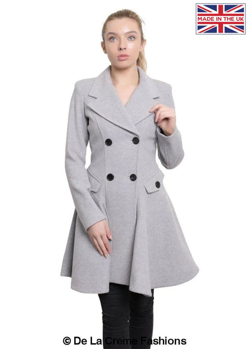 Woman modeling a De La Creme Fashions wool blend double breasted skater coat in gray, made in the UK, with elegant button details.